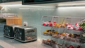 A kitchen counter with a microwave, toaster, and organized food storage bins.