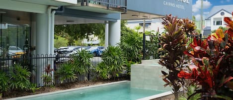 Una piscina al aire libre, sillones reclinables de piscina