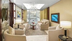 Ett modernt hotellrum med ett stort fönster, en kristallkrona och utsikt över stadsbilden.