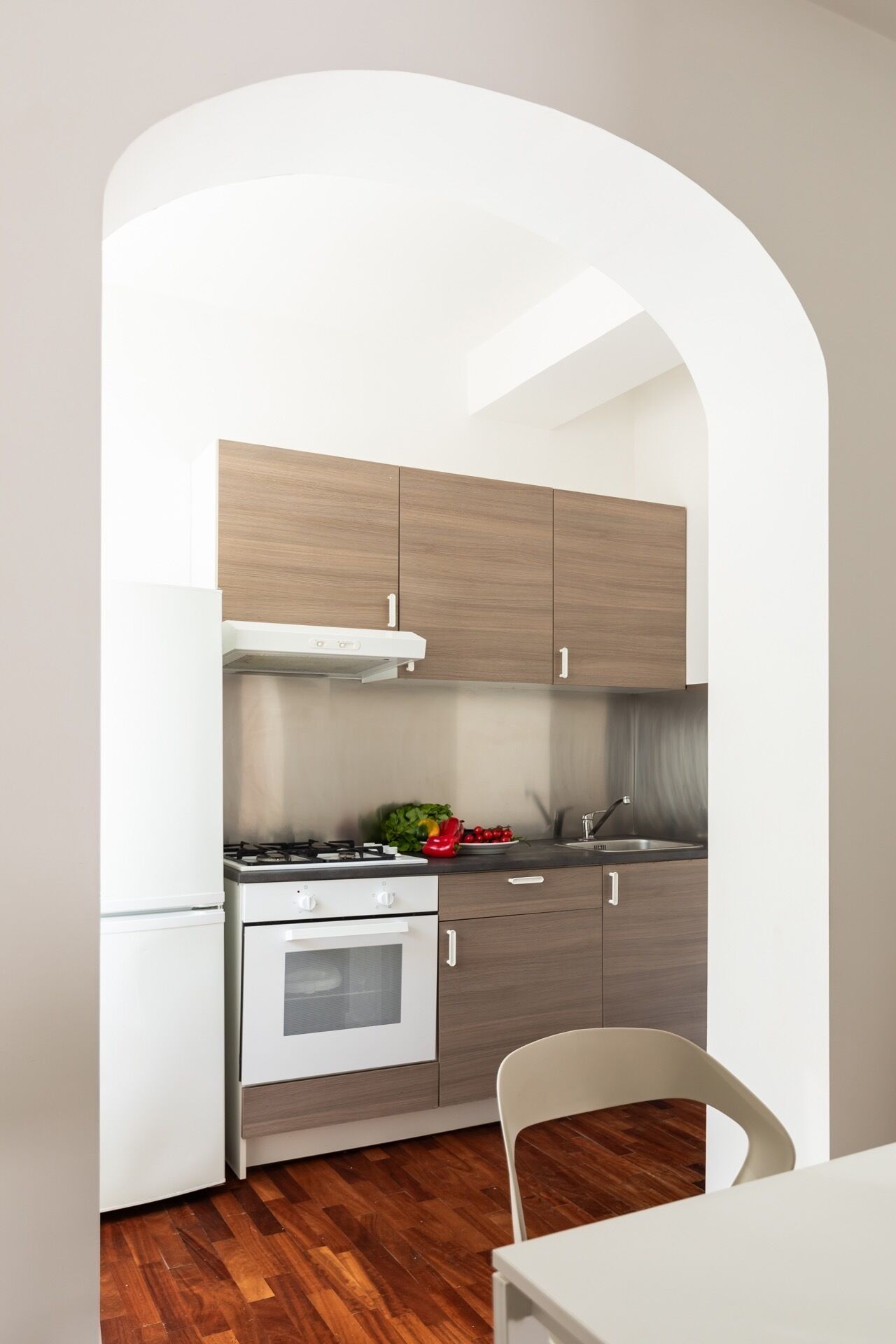 A compact kitchen with a stove, oven, and white cabinets.