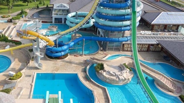A water park with multiple pools, slides, and a large building. - Garni Hotel Villa Tamara (Moravske Toplice)