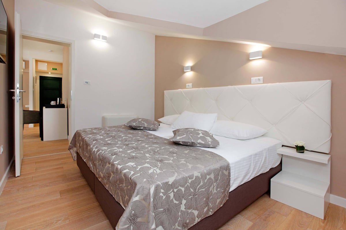 Un dormitorio con cama, mesitas de noche y un velador.
