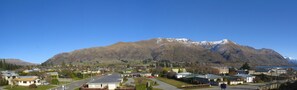 A residential area with houses, a road, and a mountain with snow-capped peaks in the background. - Clearbrook Motels Wanaka (Wanaka)