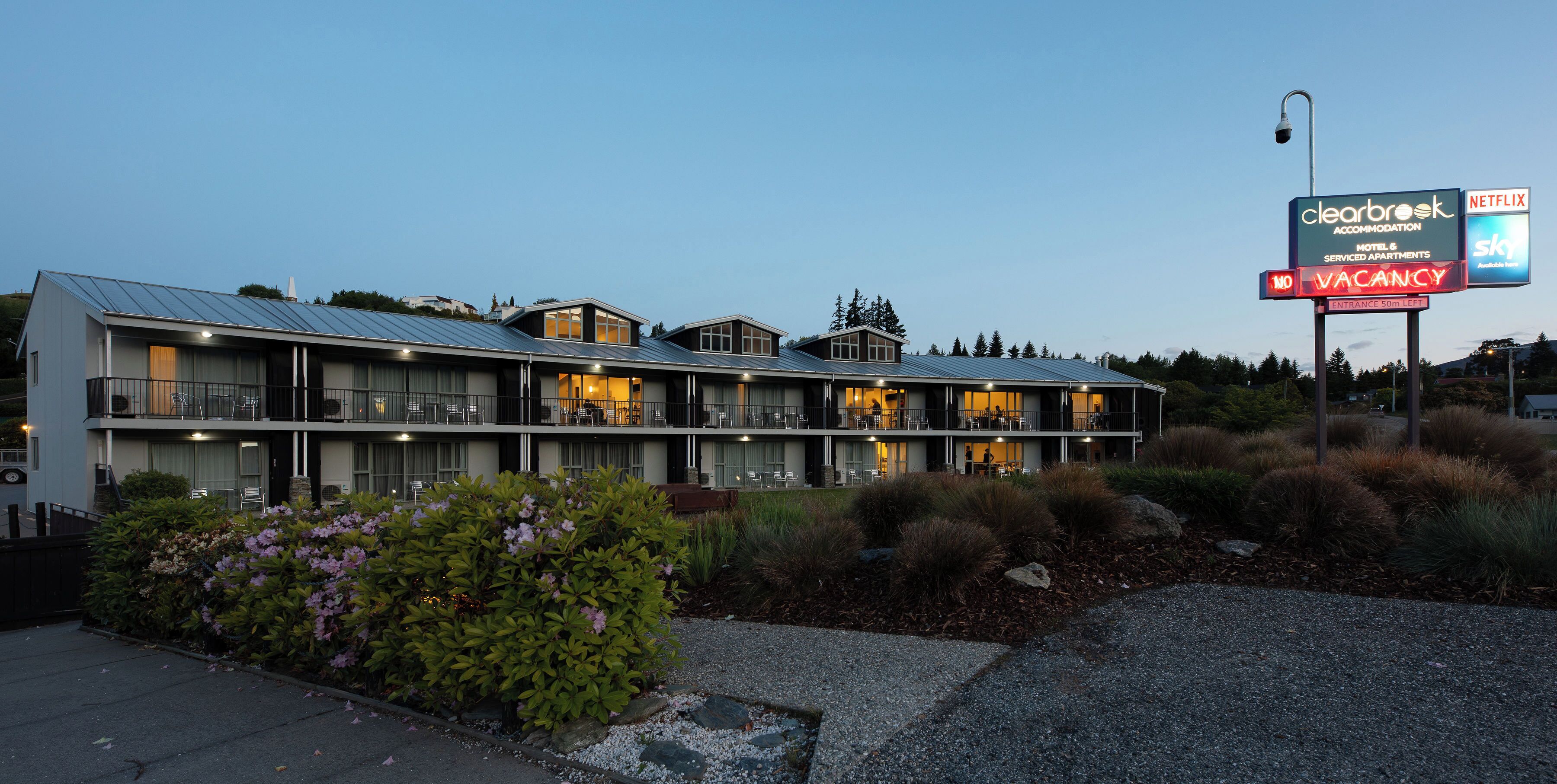 Un hôtel à plusieurs étages, doté d’une architecture moderne, de balcons et d’une façade bien éclairée.