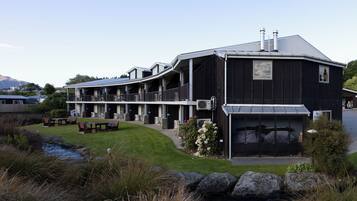A large, modern building with multiple balconies and a covered outdoor seating area.