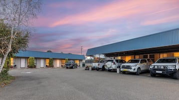 Um estacionamento com vários SUVs e um edifício com telhado azul.