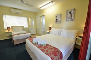 Habitación de hotel con dos camas, un ventanal con persianas, un espejo, un cuadro y una cortina roja.