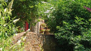 A stone wall, a red gate, and lush greenery. - Fox & Hounds Country Hotel (Chulmleigh)