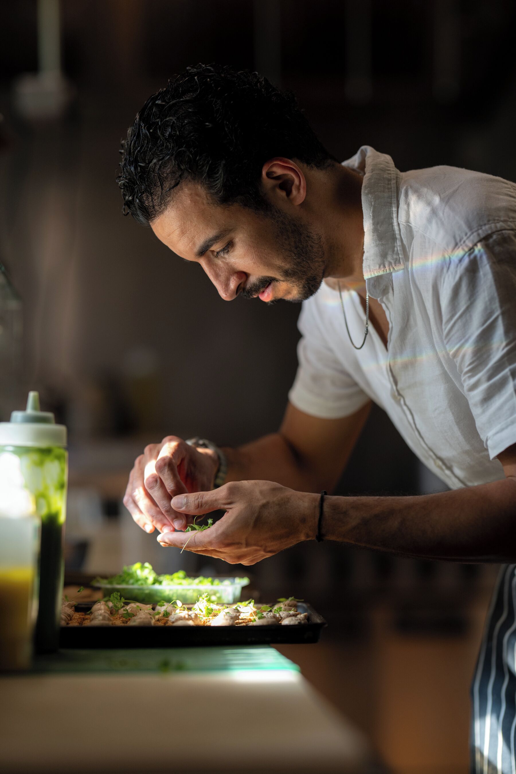 A person preparing food with a cutting board and a green container.