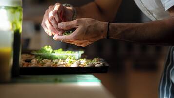 A person preparing food with a cutting board and a green container.