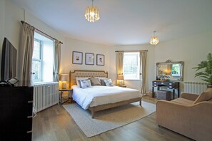 A bedroom with a bed, bedside lamps, a dresser, a chair, a desk, a mirror, and framed pictures on the wall. - Fox & Hounds Country Hotel (Chulmleigh)
