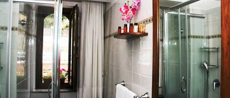 Une salle de bain avec une douche à parois de verre, un lavabo blanc et un miroir avec un cadre en bois.
