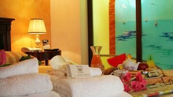 Habitación de hotel con cama, mesita de noche, lámpara, vista al mar y decoración temática tropical.