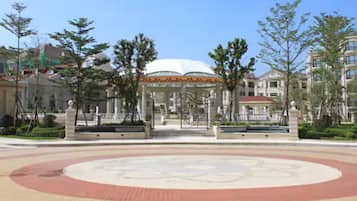 A gazebo with a dome roof, surrounded by a circular brick pathway and trees.
