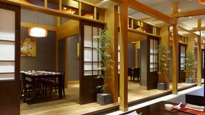 A traditional Japanese-style dining area with a wooden table set for two, surrounded by tatami mats and a low wooden partition. - E-Da Royal Hotel (Kaohsiung)