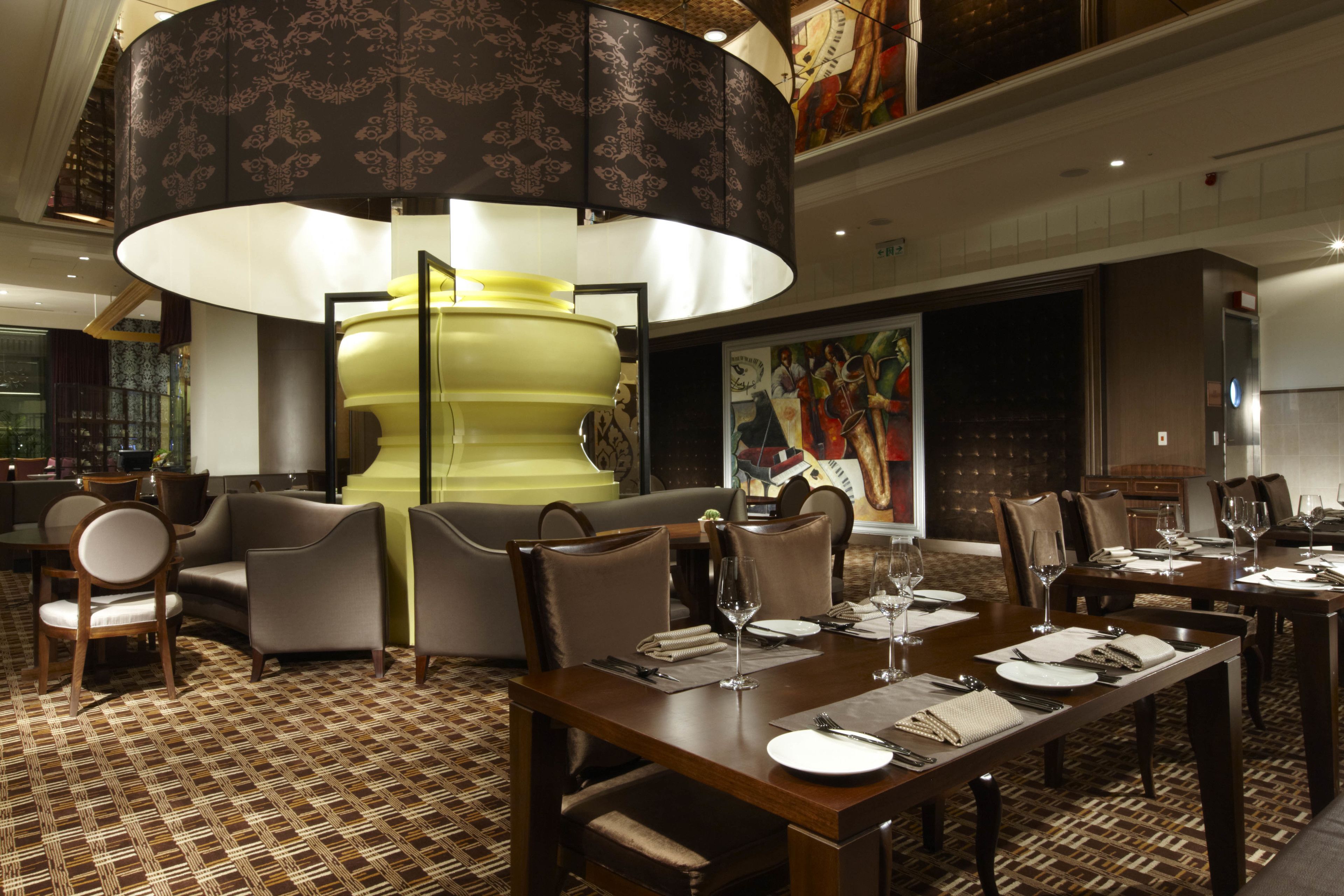 A dining area with a large table set for a meal, surrounded by chairs, and a decorative lamp overhead.