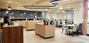 A modern restaurant with a black and white patterned wall, wooden furniture, and a central counter.