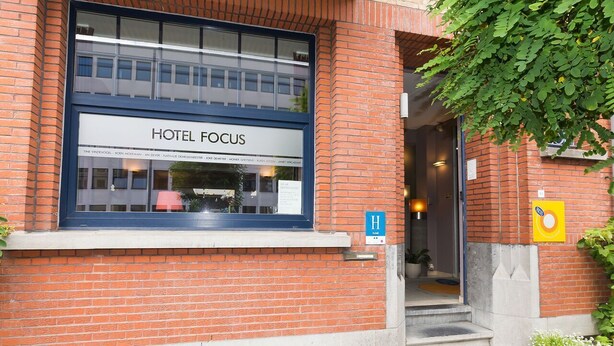 A hotel entrance with a large window displaying the name "HOTEL FOCUS". - Focus Hotel (Kortrijk)