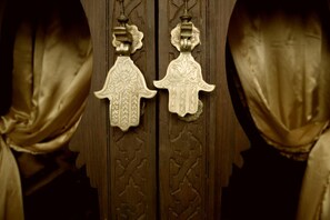 Two ornate door knockers with intricate designs on a wooden door. - Riad Des Arts (Marrakech)