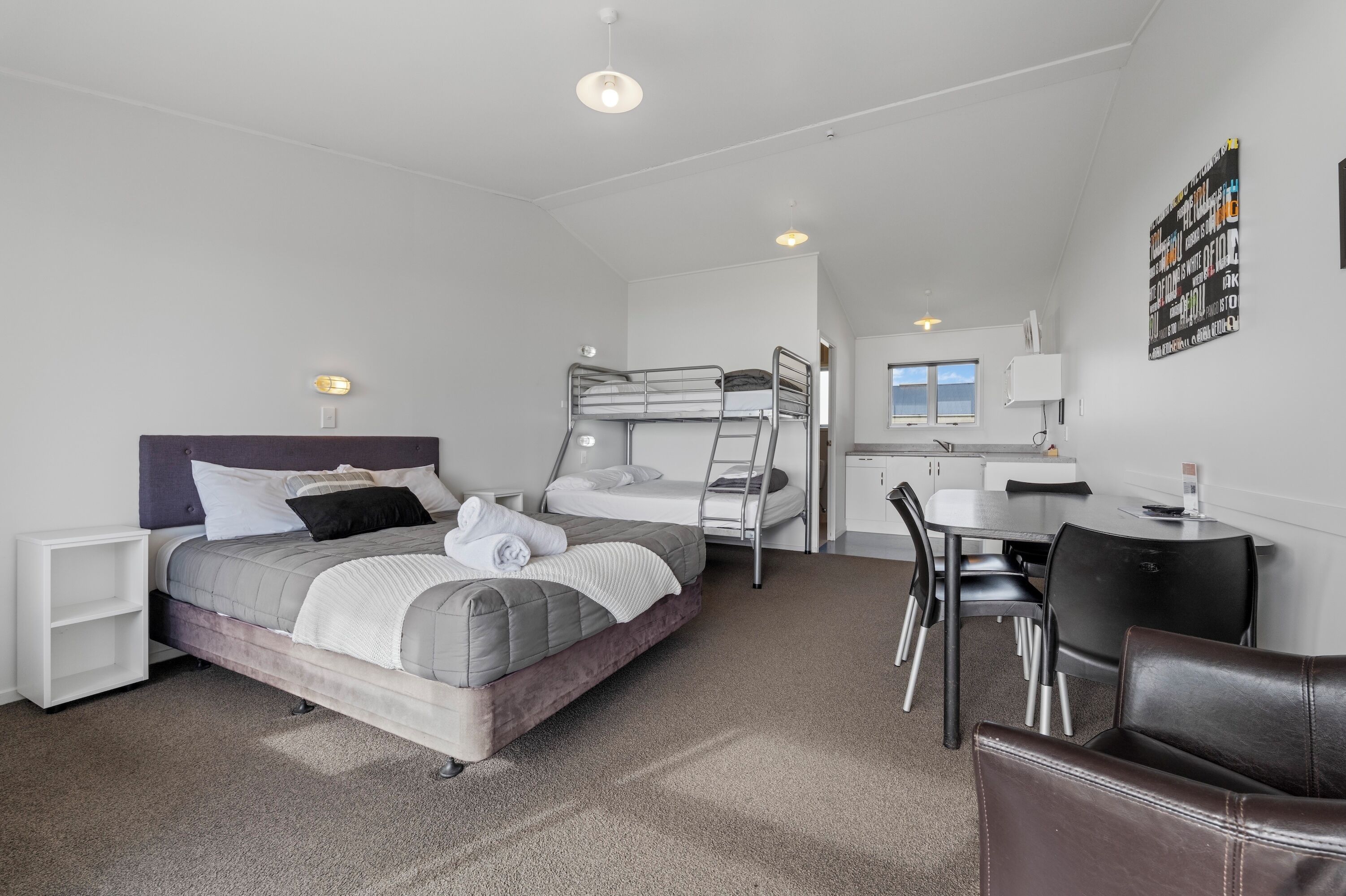 A compact room with a bunk bed, a desk, and a chair.