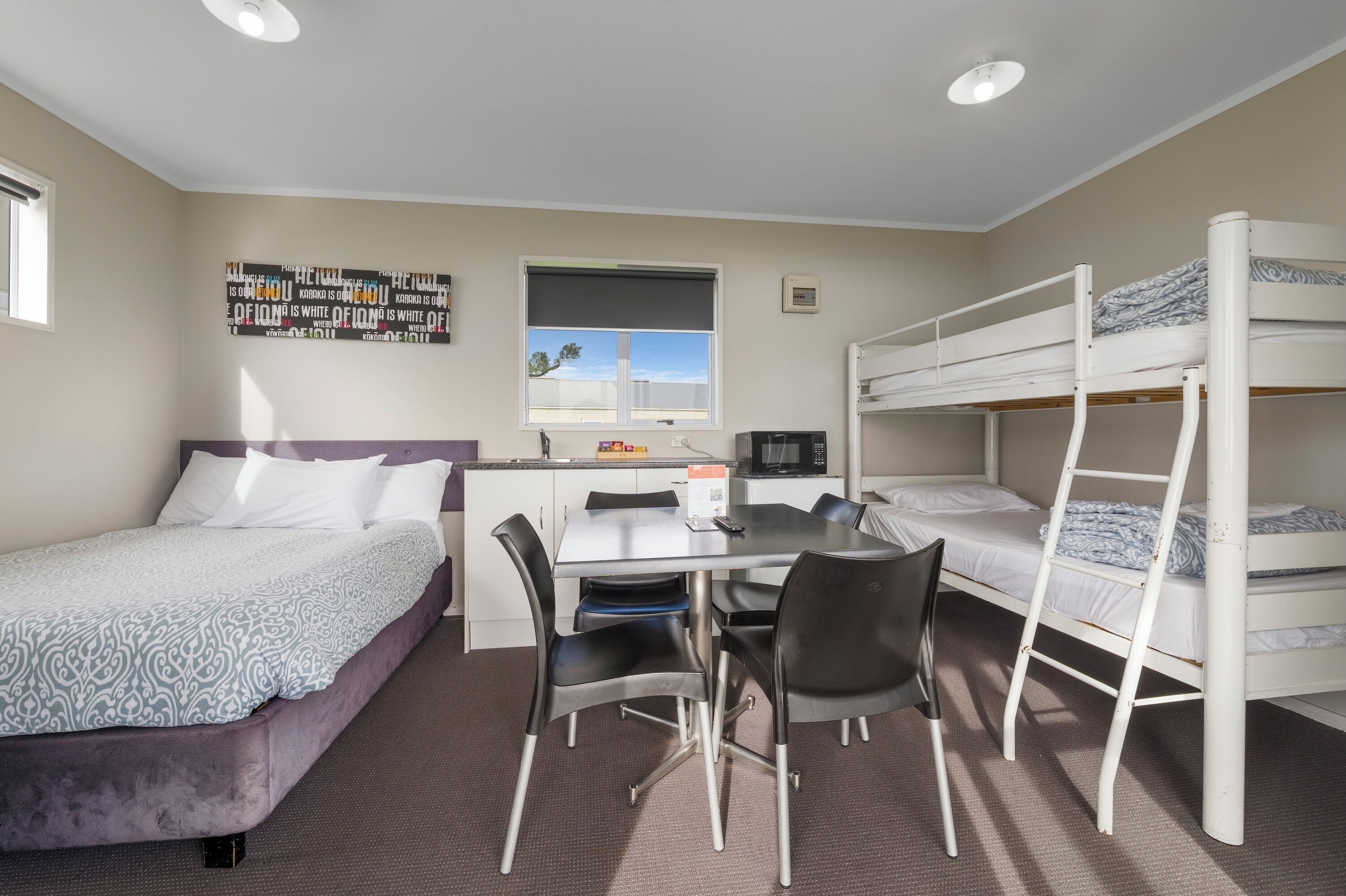 A compact room with bunk beds, a desk, and a chair.