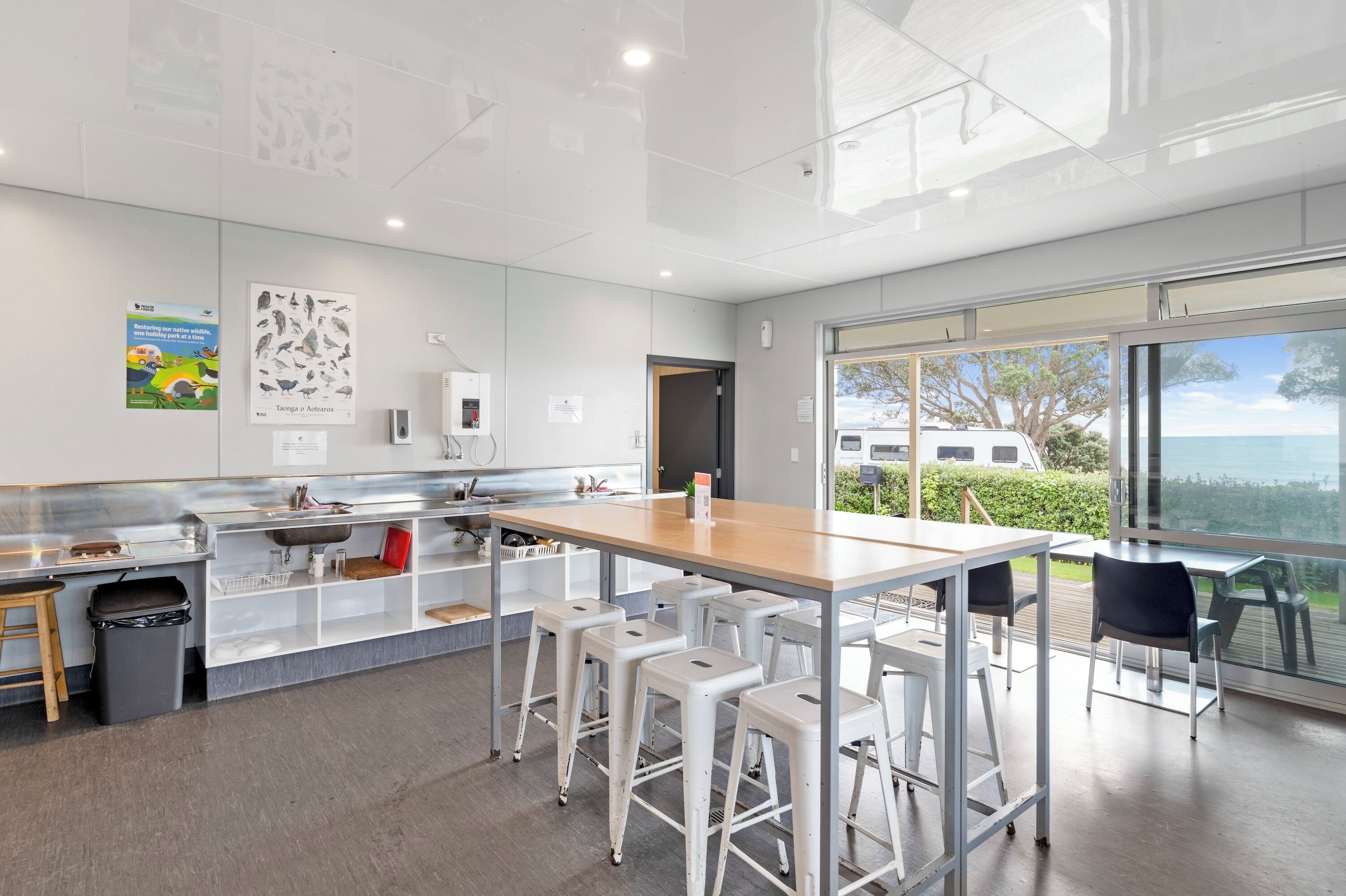 Una cocina moderna con una isla central, taburetes de bar y vistas al exterior.