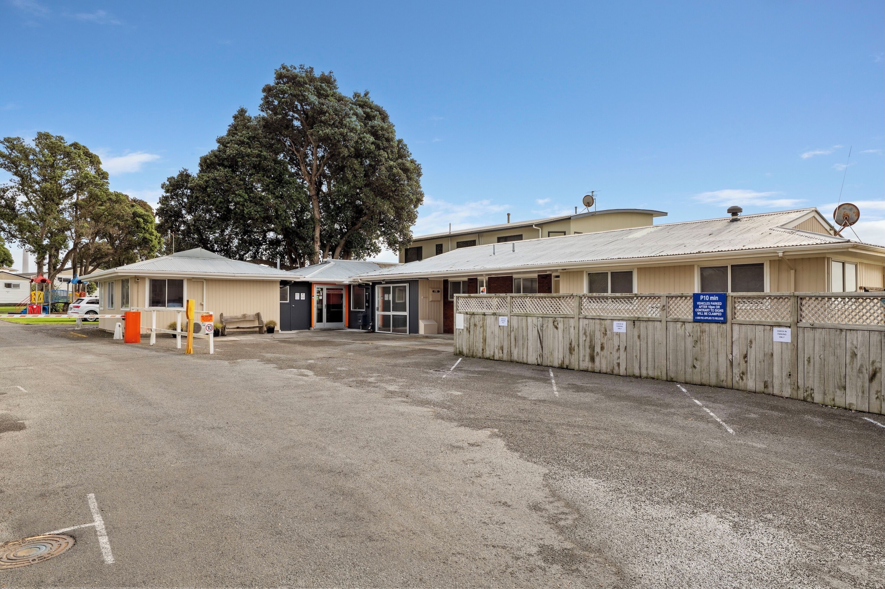 Un motel doté d’un parking clos, d’un comptoir d’accueil et d’un bâtiment équipé d’une antenne parabolique.