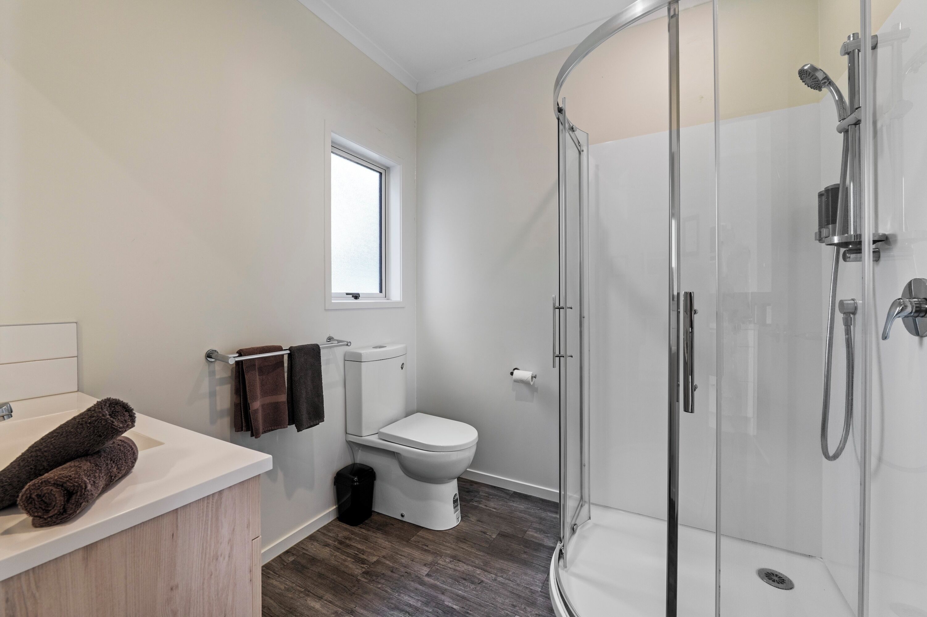 Un baño moderno con ducha, inodoro y lavamanos.