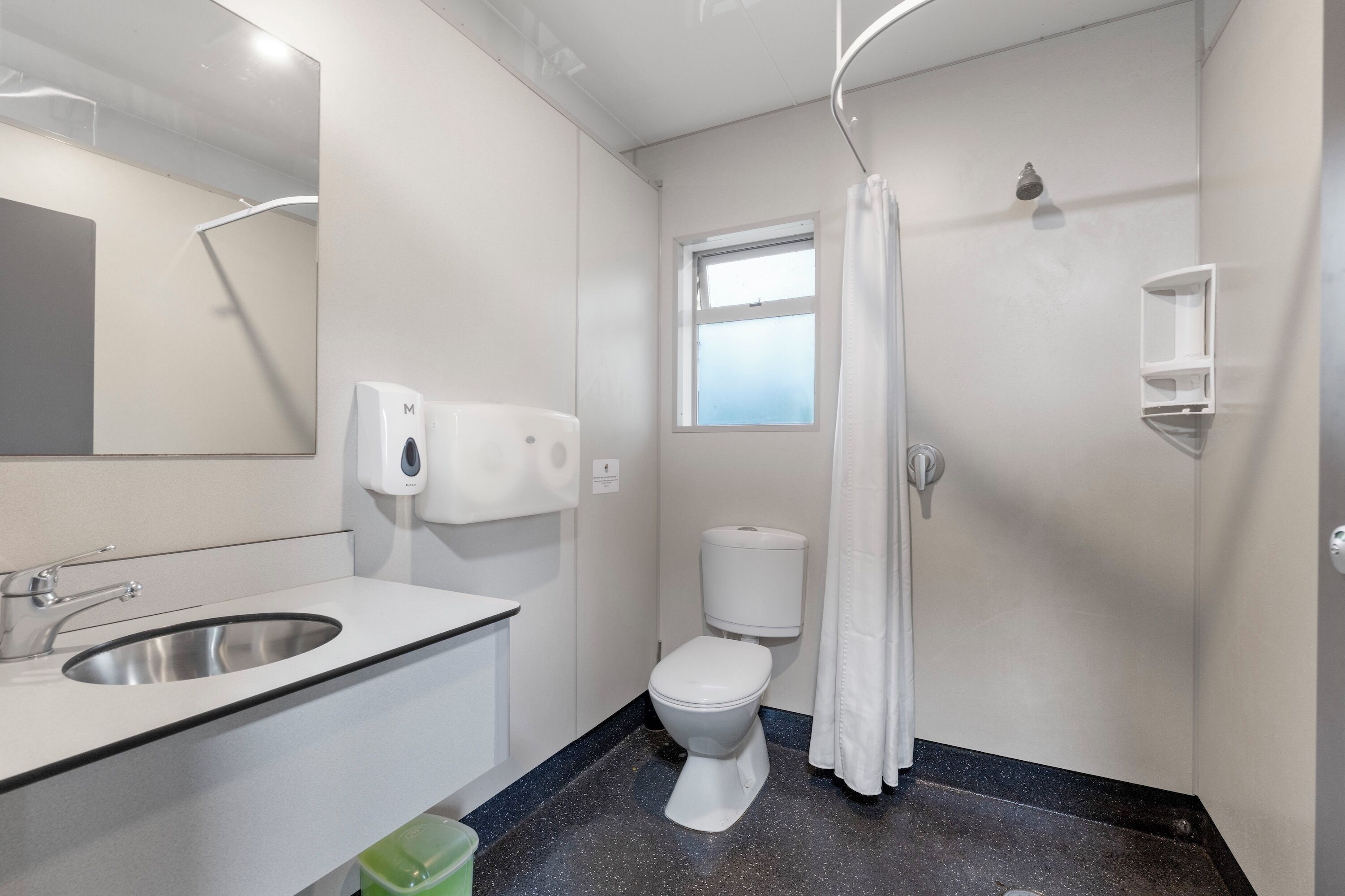 A modern bathroom with a sink, toilet, and shower.