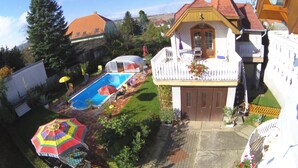 A residential property with a swimming pool, a fenced garden, and a balcony with a flower box.