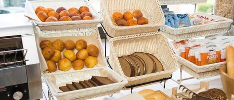 Un buffet de petit-déjeuner proposant un assortiment de pains, de viennoiseries et de céréales.