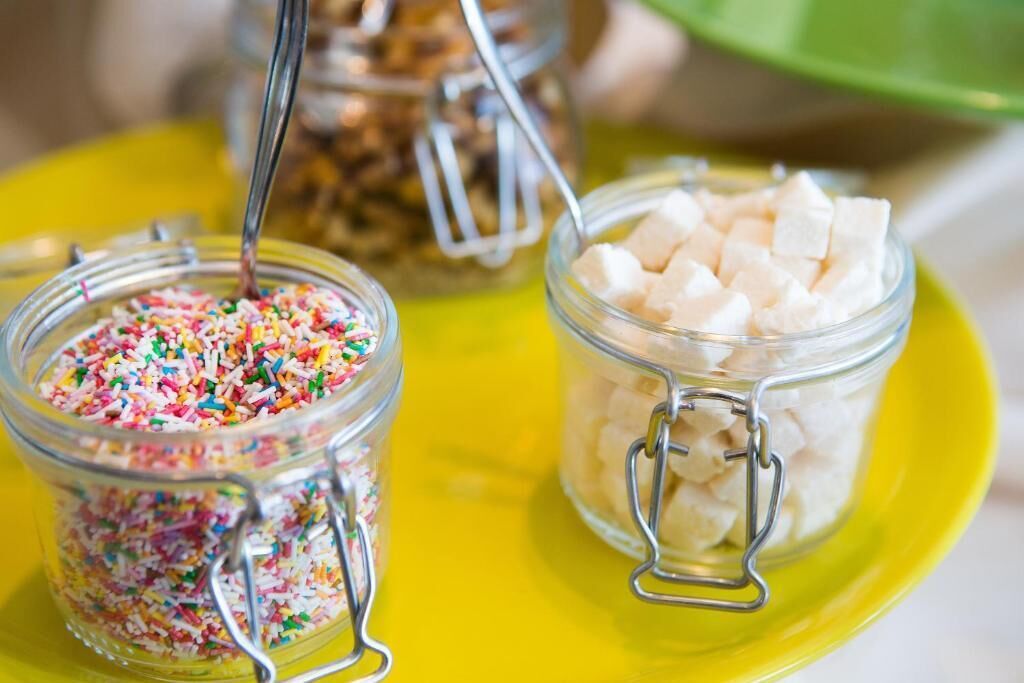 Three glass jars with metal clasps on a yellow plate.