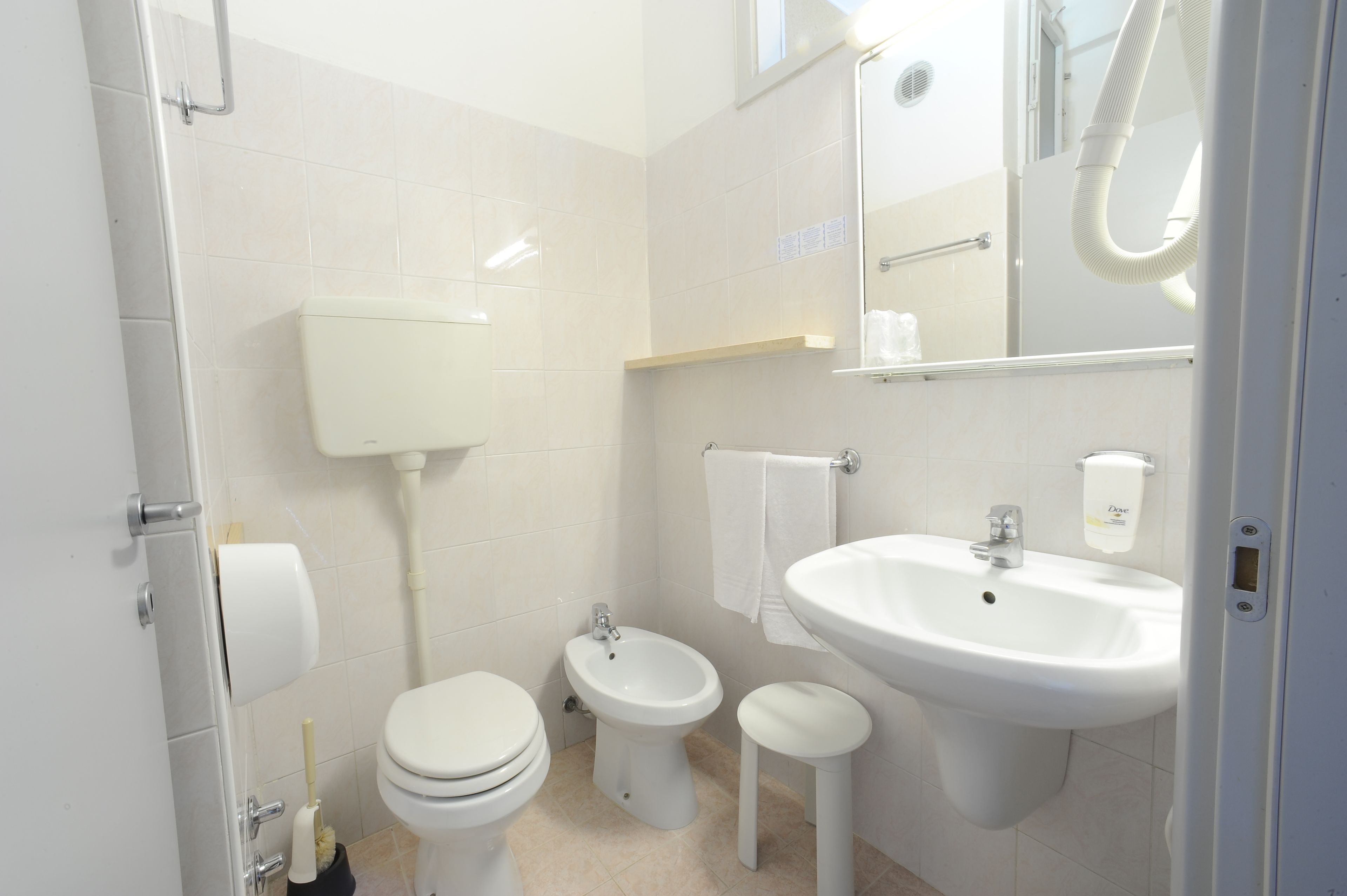 A modern bathroom with a toilet, bidet, and sink.