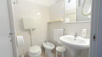 A modern bathroom with a toilet, bidet, and sink.
