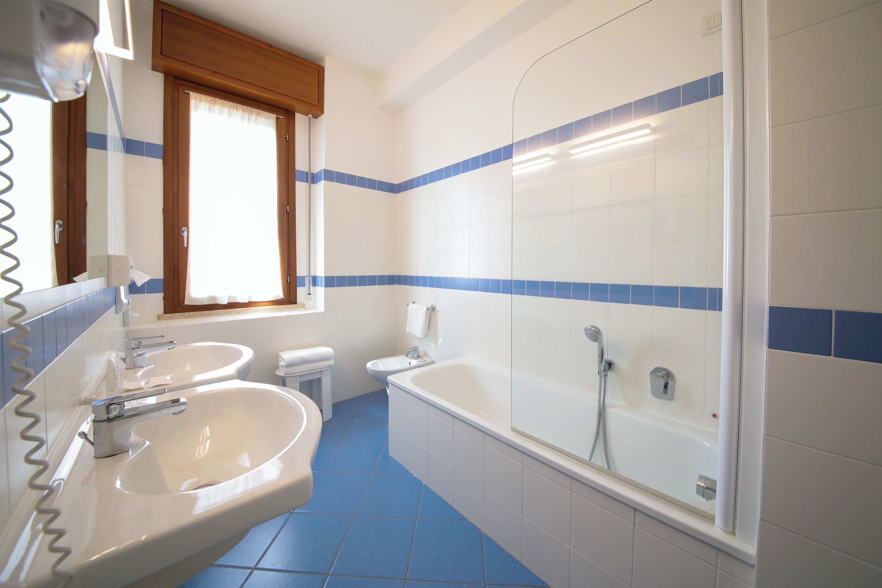 A bathroom with two sinks, a bathtub, and a shower.