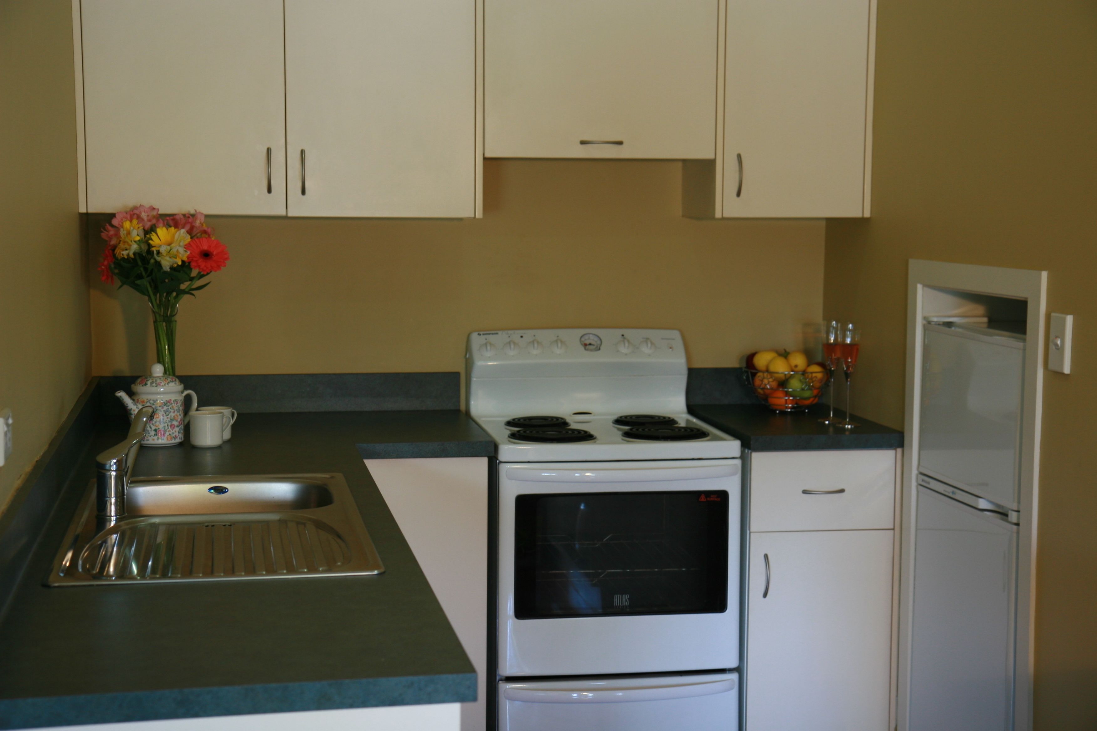 A kitchen with a stove, oven, sink, and cabinets.
