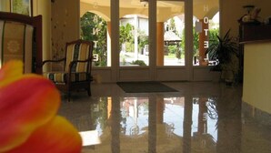 A lobby with a polished floor, a chair, and a door leading outside. - SANTE Hévíz (Hévíz)