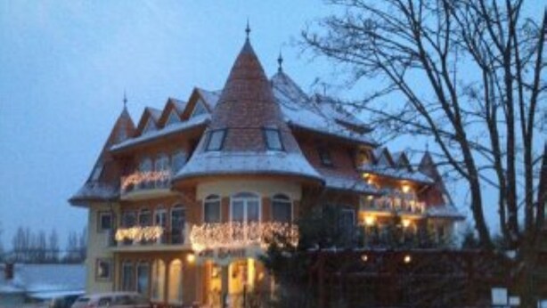 A large, multi-story house with a steeply pitched roof and a prominent tower. - SANTE Hévíz (Hévíz)
