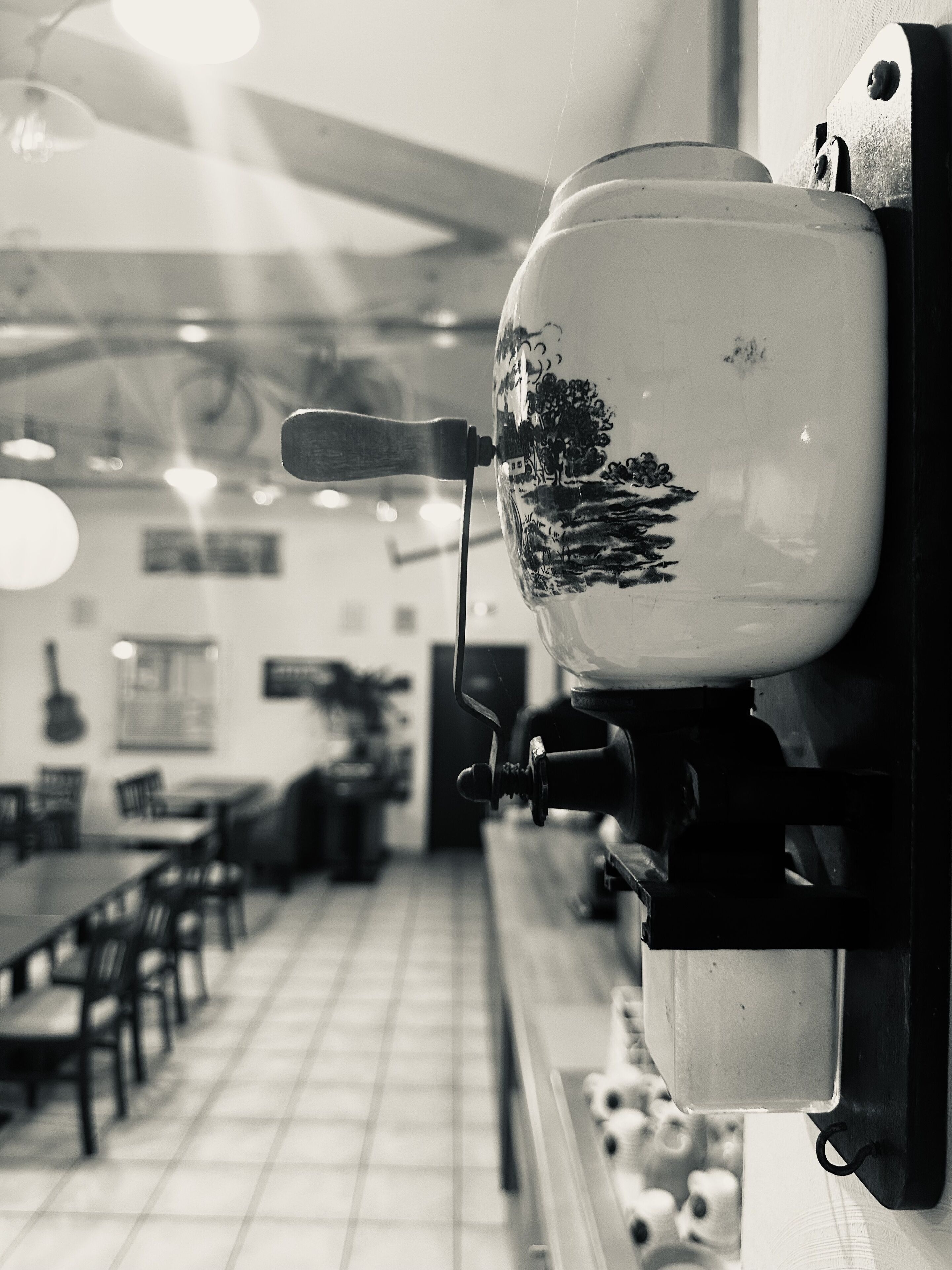 Een koffieapparaat in een restaurant met een betegelde vloer en tafels.