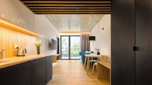 Une cuisine moderne avec un plan de travail en bois, des meubles noirs et une grande fenêtre.