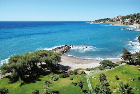 Playa privada, arena negra, sillas reclinables de playa, sombrillas