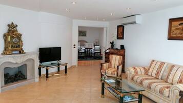 A living room with a fireplace, a television, a sofa, and a coffee table.