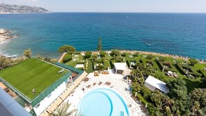 Un complexe hôtelier doté d’une piscine, d’un court de tennis et offrant une vue sur la mer.