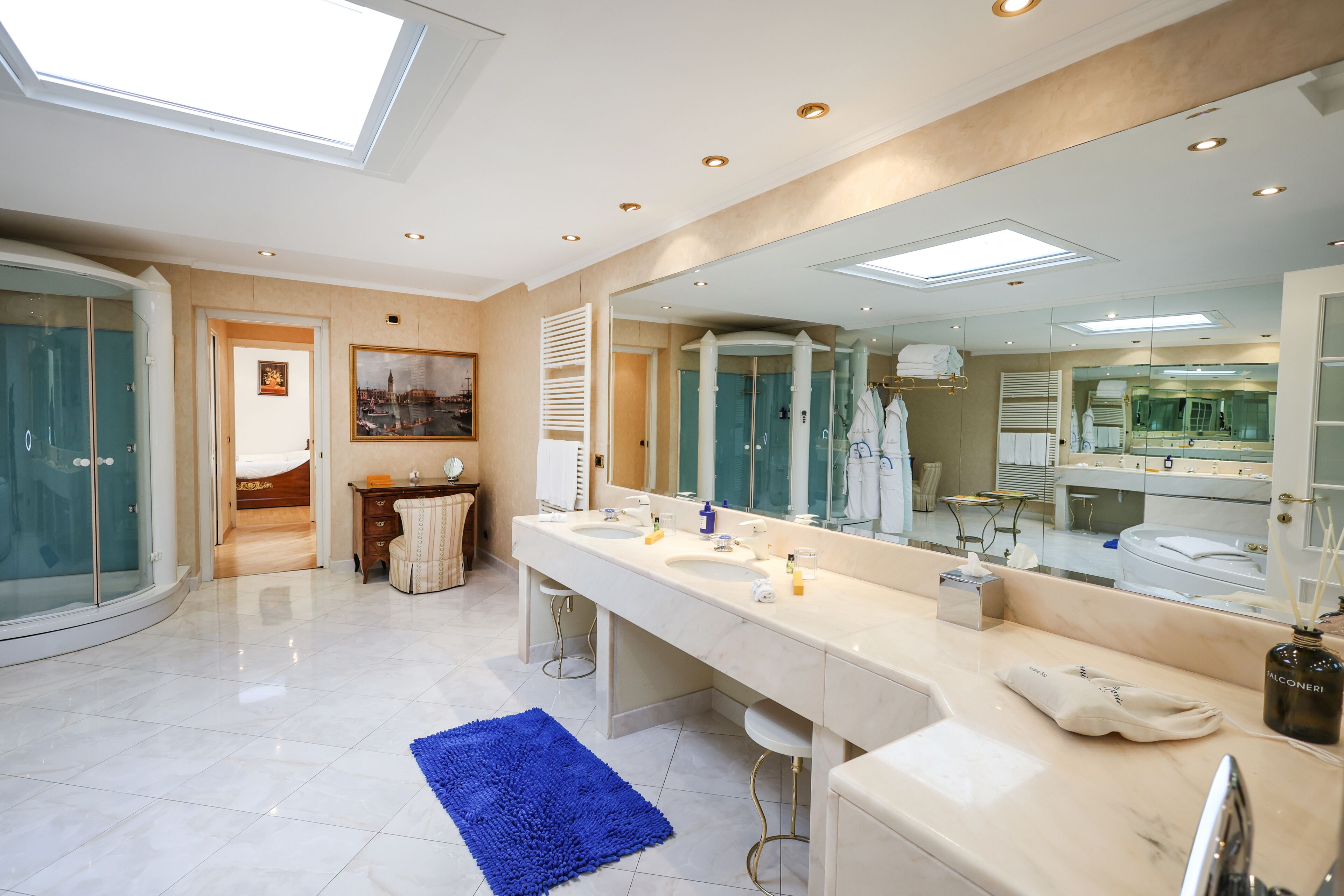 Ein modernes Badezimmer mit Oberlicht, großem Spiegel und barrierefreier Dusche.