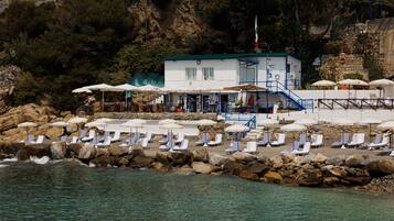 Plage privée, sable noir, chaises longues, parasols