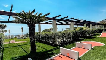 Un espace extérieur bien entretenu, agrémenté d’une pergola, d’une pelouse verdoyante et d’un ciel dégagé.