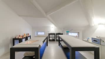 Une chambre moderne et minimaliste, avec un lit central, deux tables de chevet, une petite fenêtre et un lave-linge encastré.