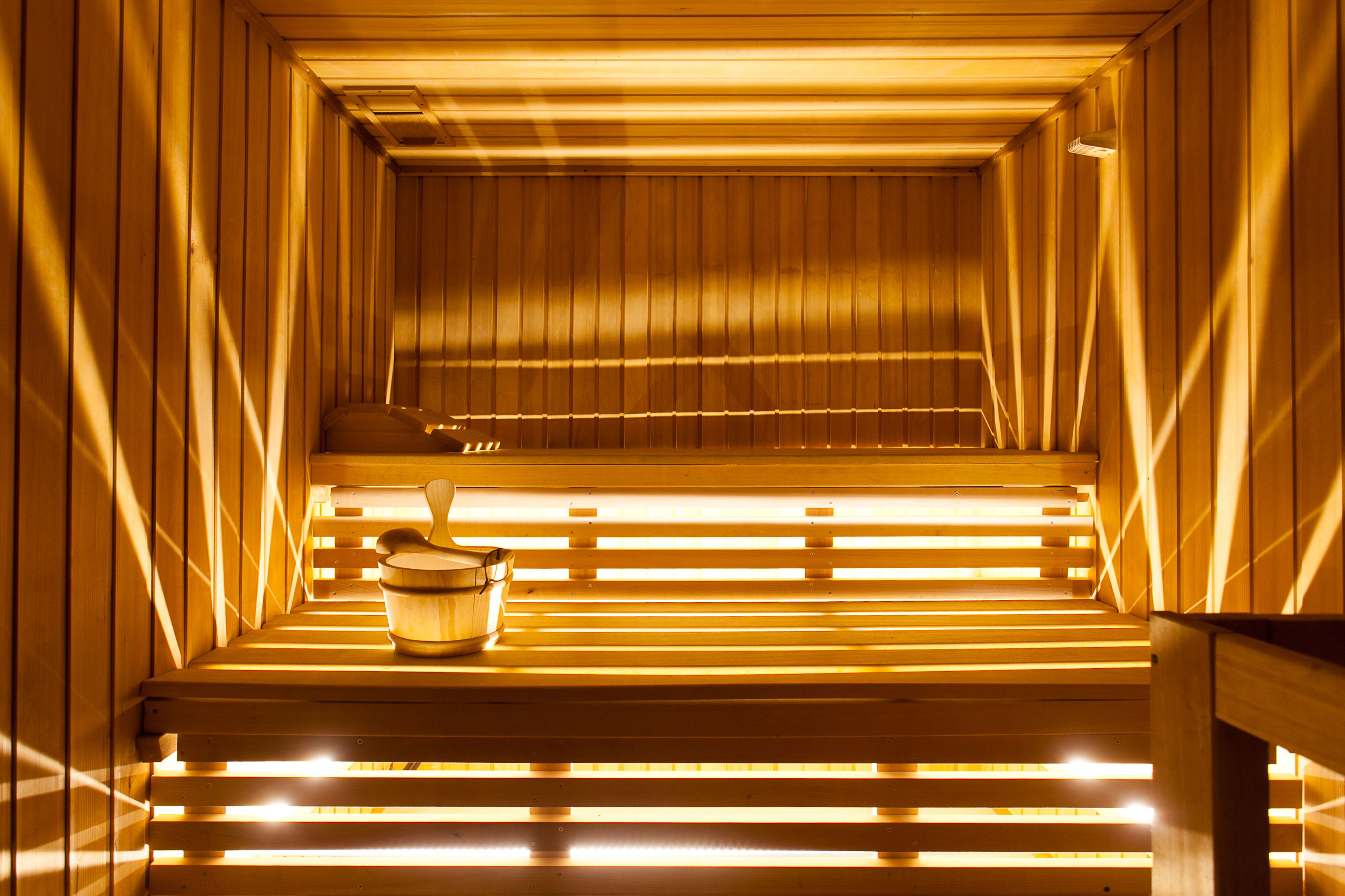 Eine Sauna mit Holzbänken und einem Eimer.