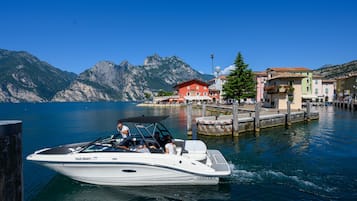 A boat docked at a pier with a mountainous backdrop.