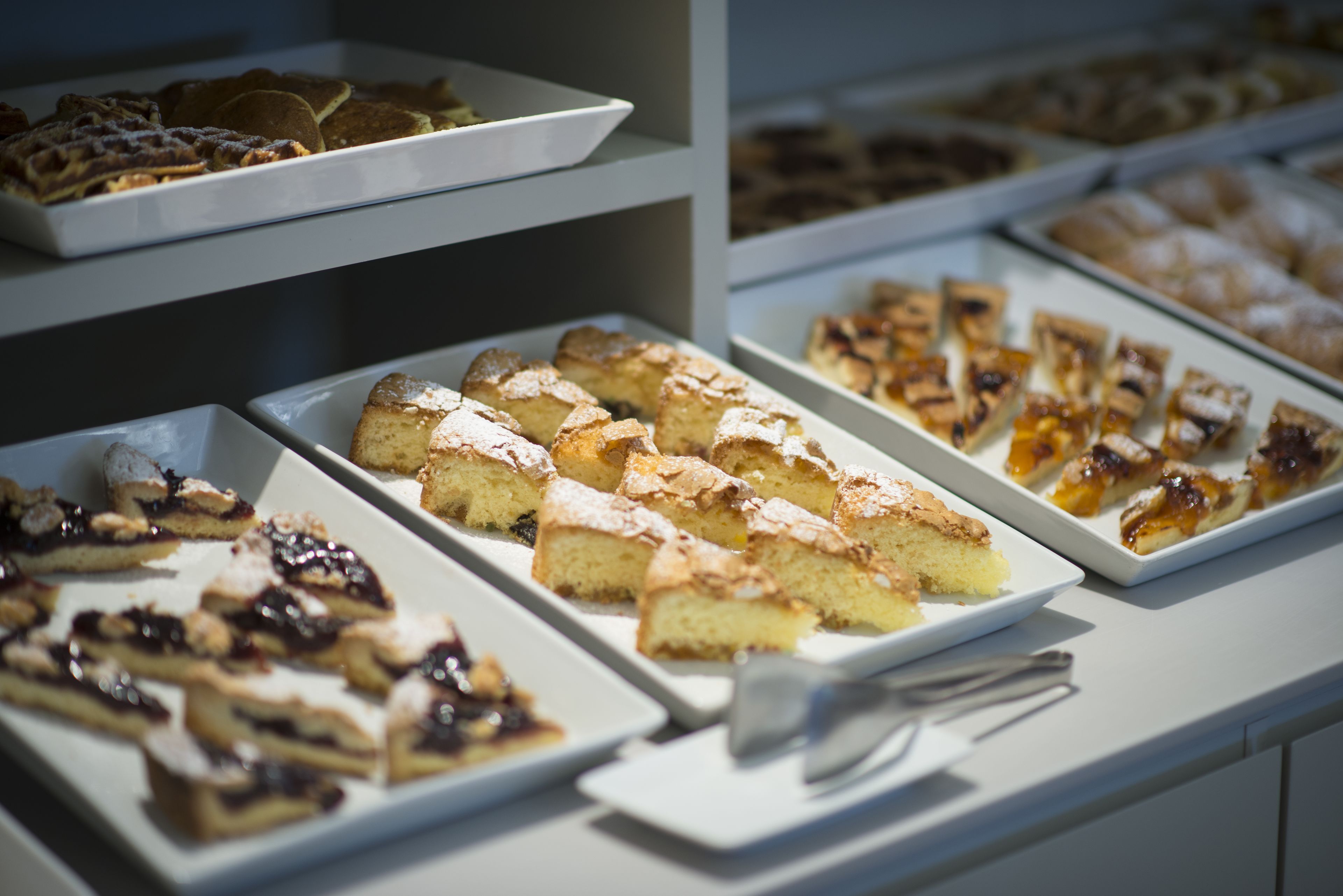 A display of various pastries and desserts on trays.